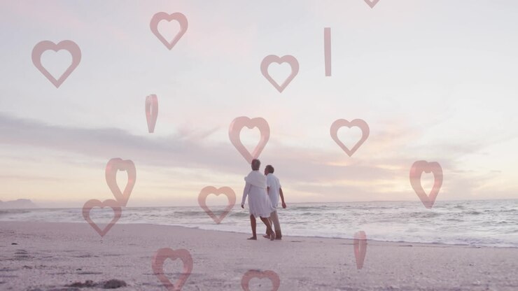 Coppia che cammina sulla spiaggia, con un'animazione a forma di cuore sovrapposta a una serena scena oceanica.