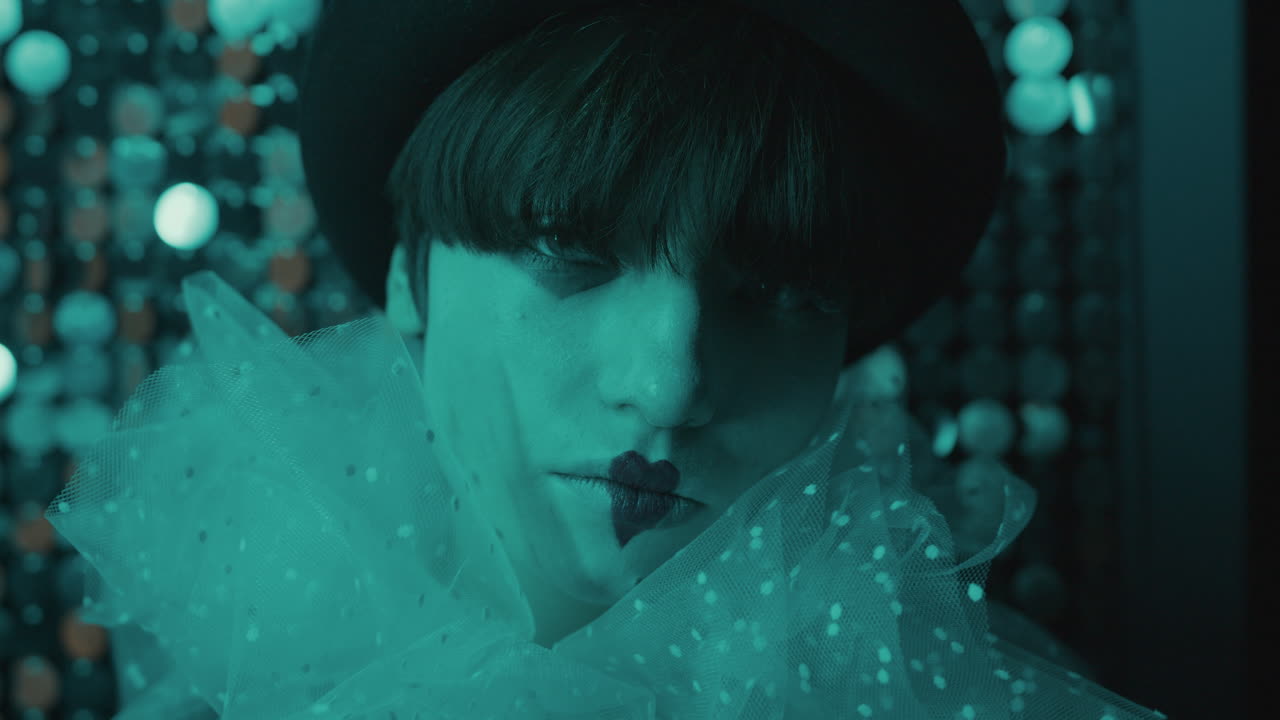 밝은 벽에 기대어 있는 젊은 여성의 근접 사진