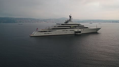 large luxurious, expensive yacht sailing vessel floating in coastal ocean seascape during sunset