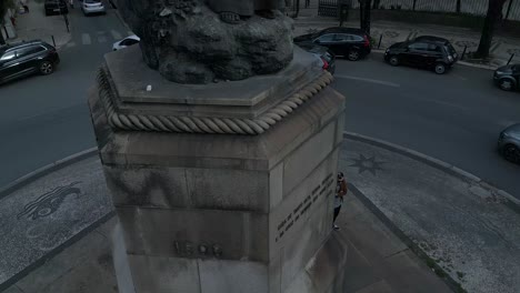 Luftaufnahme-Von-Unten-Nach-Oben-Auf-Den-Zentralen-Platz-Mit-Der-Statue-Von-Pedro-Álvares-Cabral-Und-Einem-Schild,-Das-Die-Menschen-In-Lissabon-Willkommen-Heißt