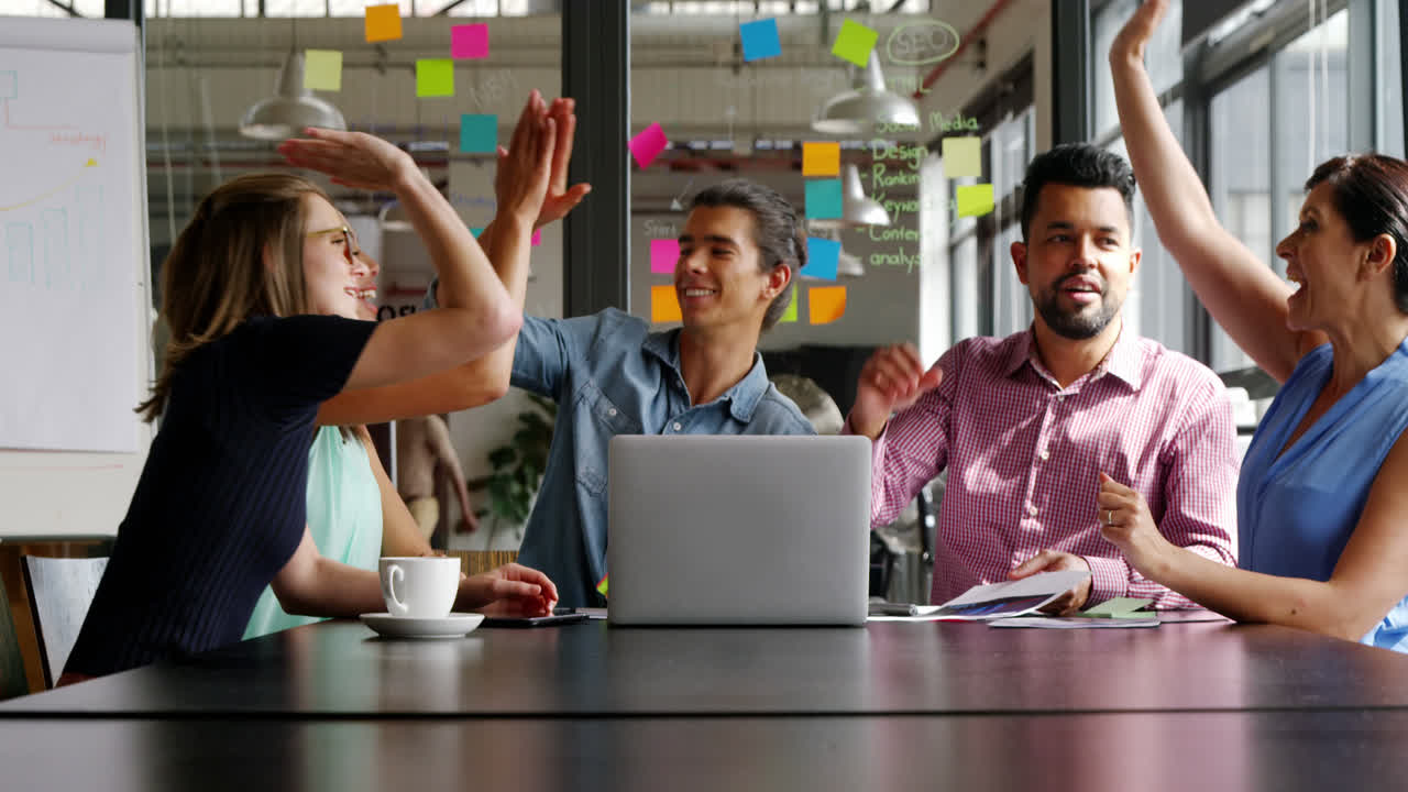 Business executive giving high five in office