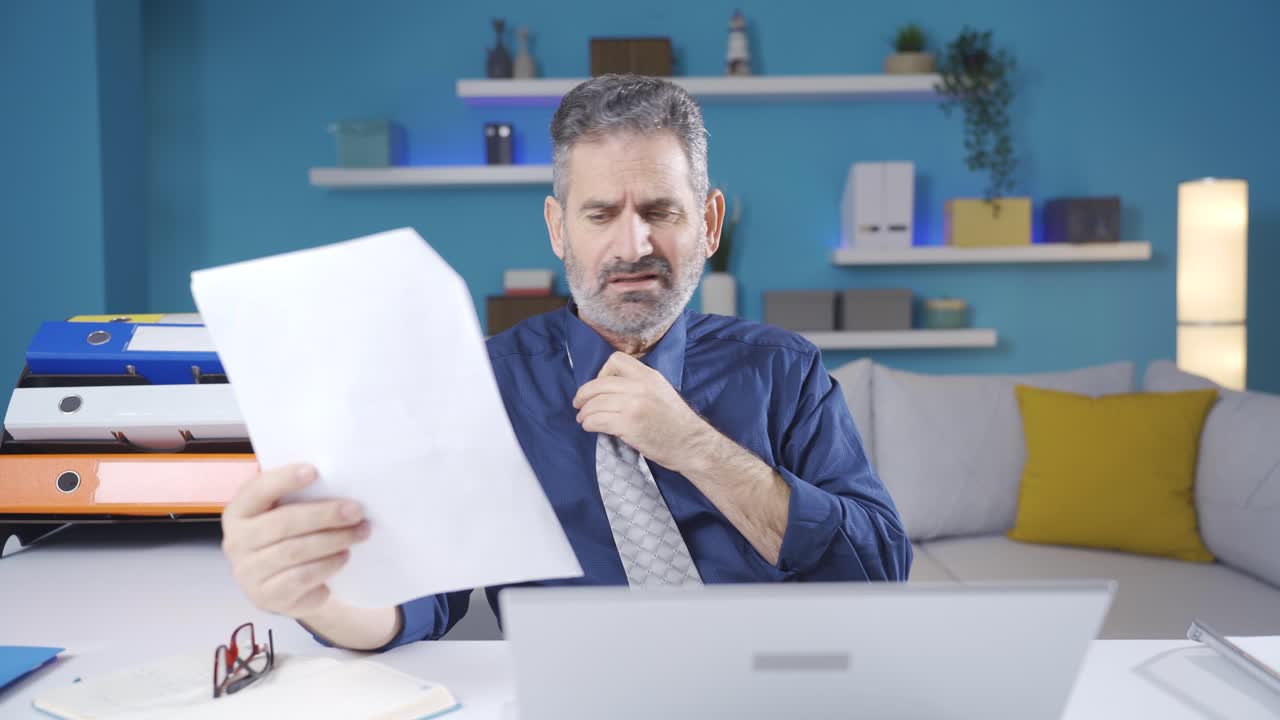 el hombre de negocios que se entristece al ver que las cosas no van bien después de lo que ve en el papel.