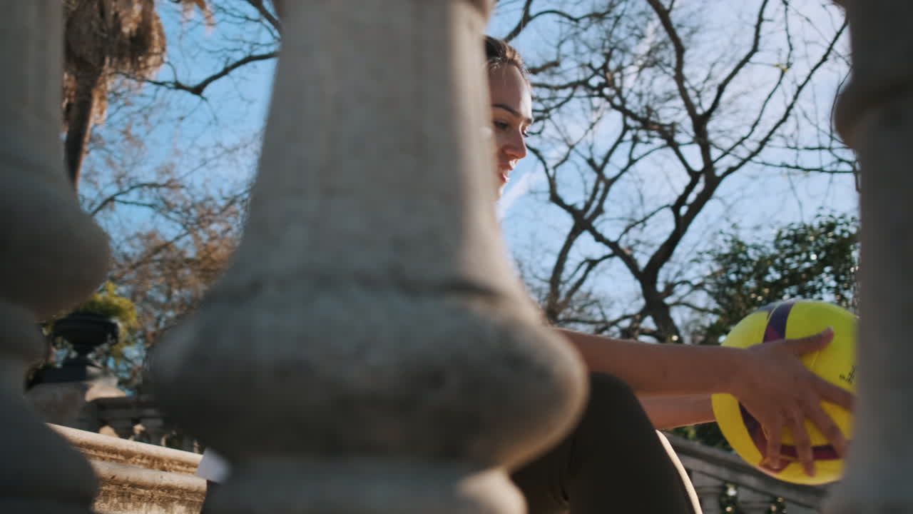 야외에서 손에 축구공을 들고 있는 스포츠 여성.