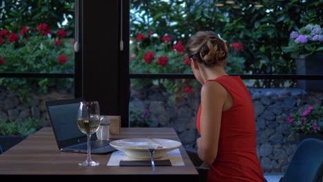 hermosa mujer cenando sola usando el teléfono para revisar sus dientes y luego usando el cepillo interdental para limpiar los dientes en un restaurante de mercado alto