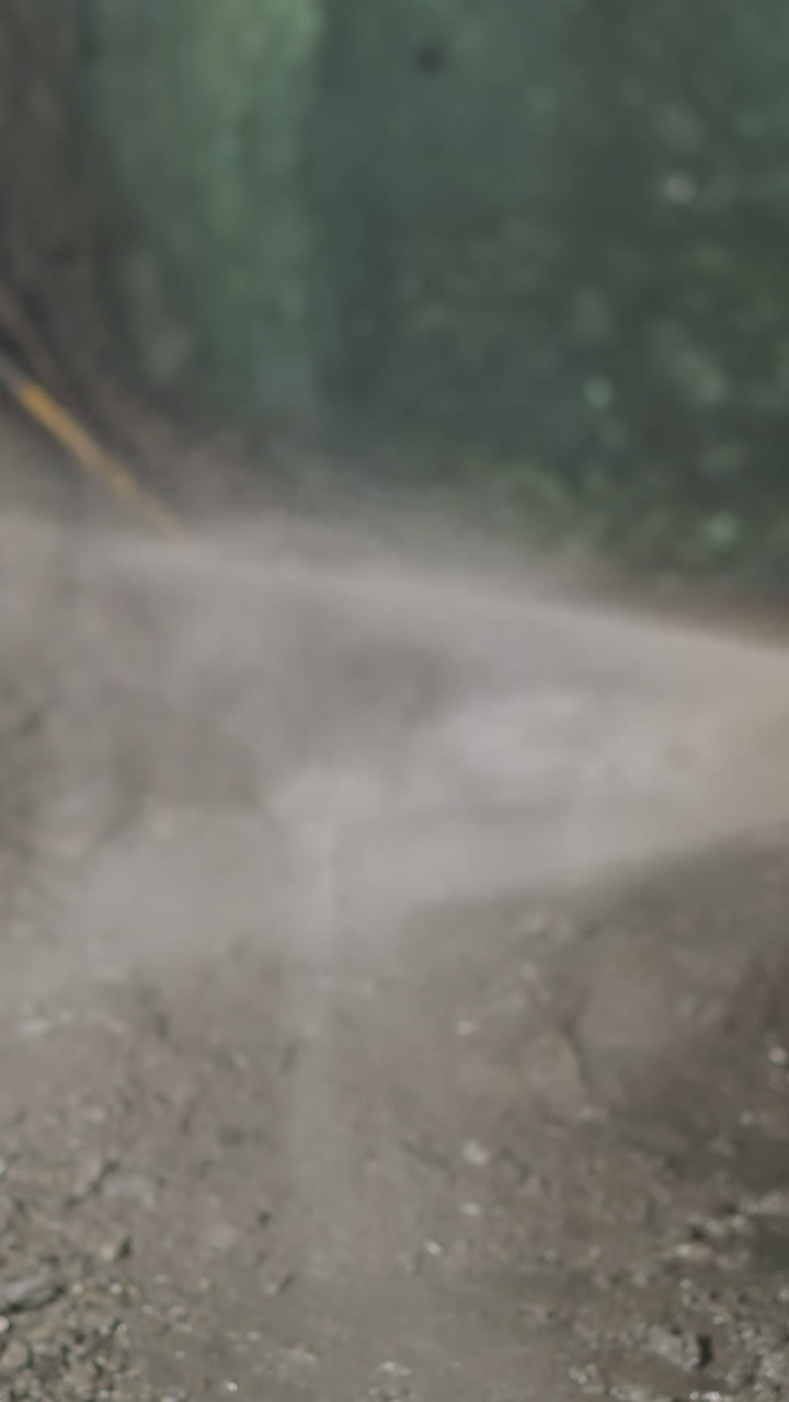 Heavy machinery equipment with coolant and robot drill operates in ore mine. Cold water sprayed to cool soil during rock drilling process closeup