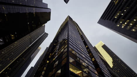 skyward view of modern skyscraper amidst urban architecture in twilight