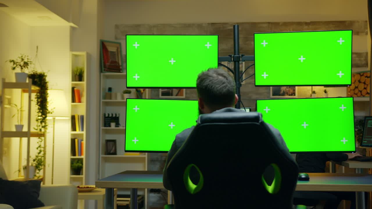 Back view of hacker using computer with multiple screen