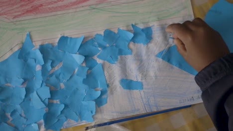 child's art project: creating a blue paper collage