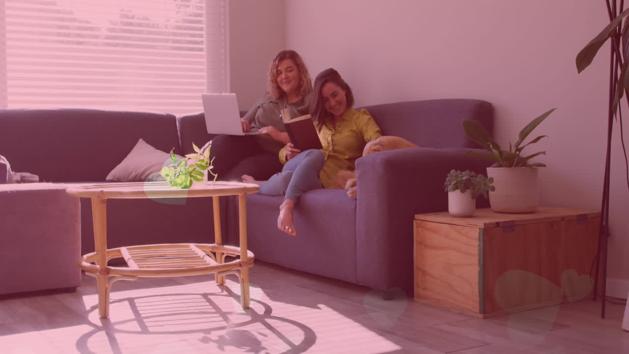 행복한 백인 레즈비언 커플이 집에서 소파에 앉아 있는 심장의 애니메이션