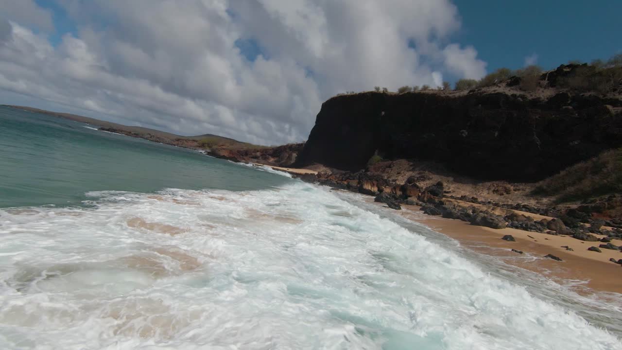 Low high speed FPV drone flight over breaking waves towards Hawaiian beach