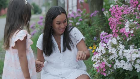 little girl admiring flowers with her mother