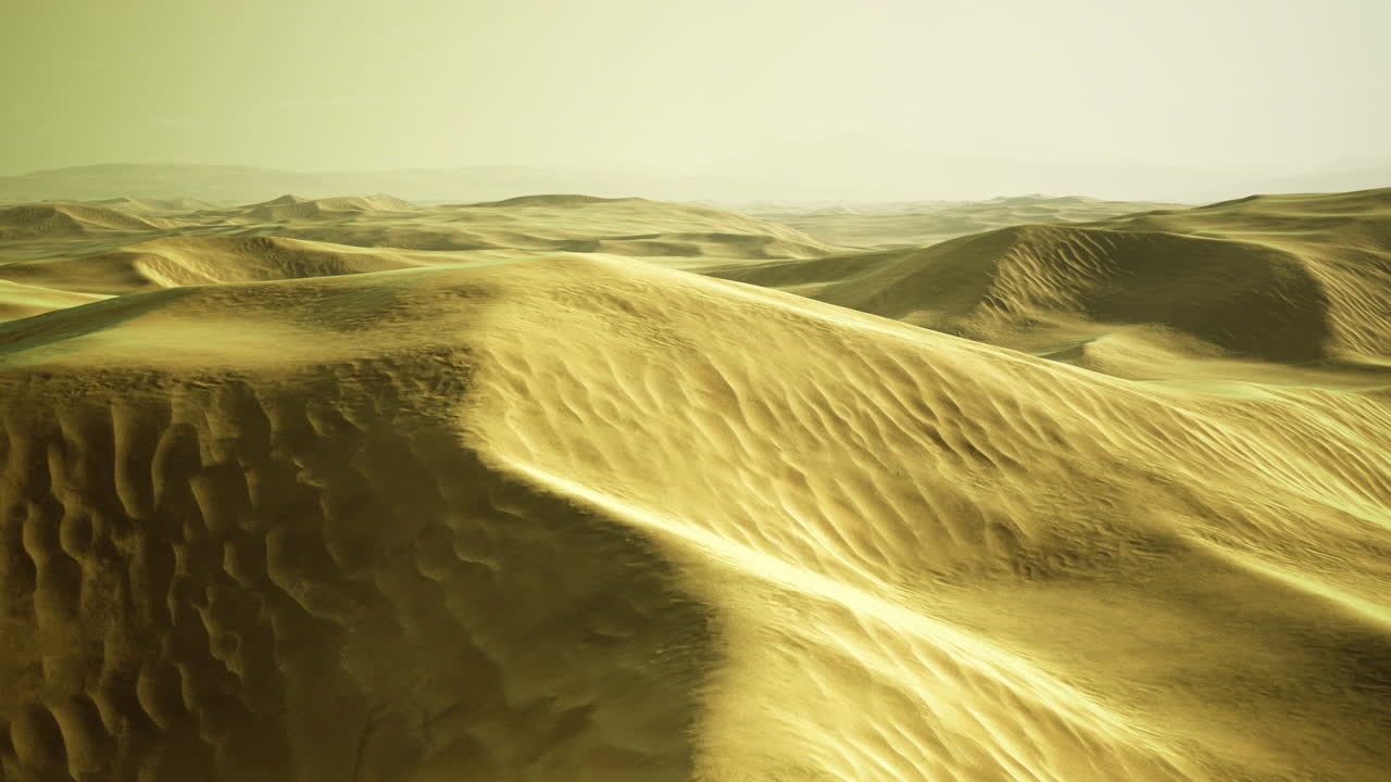 Golden dunes stretch across a tranquil desert under a hazy sky