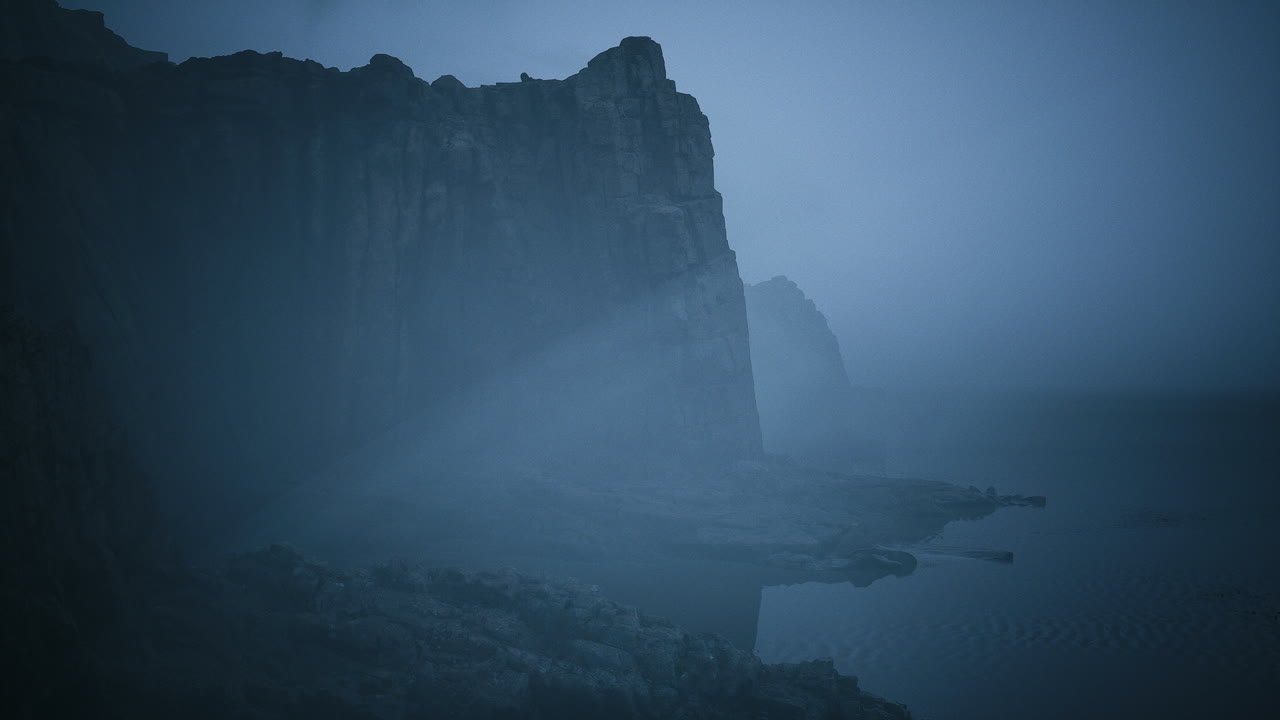 Mysterious coastal cliffs shrouded in fog during twilight hours