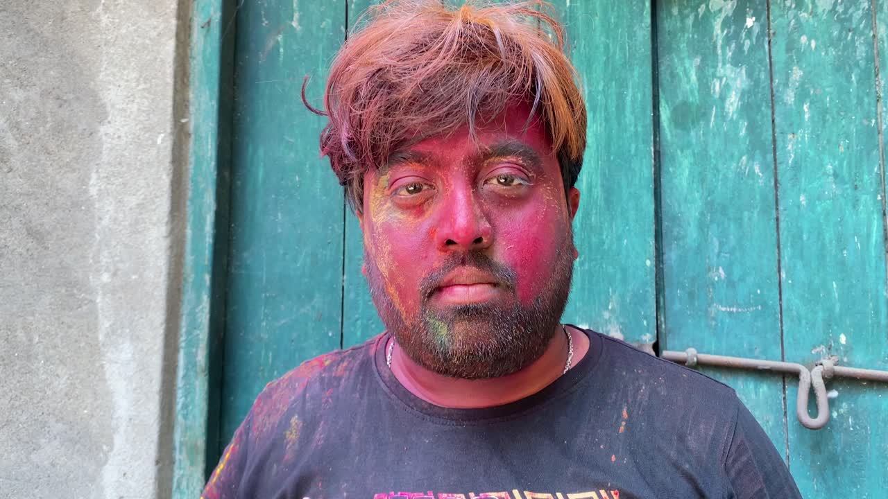 una toma estática de un niño quitándose la máscara de la cara después de jugar holi frente a la cámara