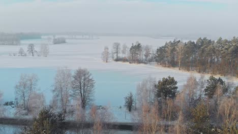 Drohnenaufnahme-Eines-Autos,-Das-In-Einem-Verschneiten-Wald-In-Norwegen-Fährt