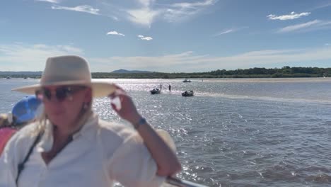 mature woman passenger tourist on boat or ferry enjoys sunny day on noosa river