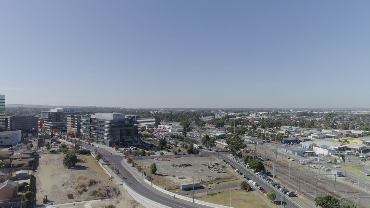 White birds flying through foreground of aerial perspective looking out over newly developed infrastructure in Dandenong, Victoria, Australia