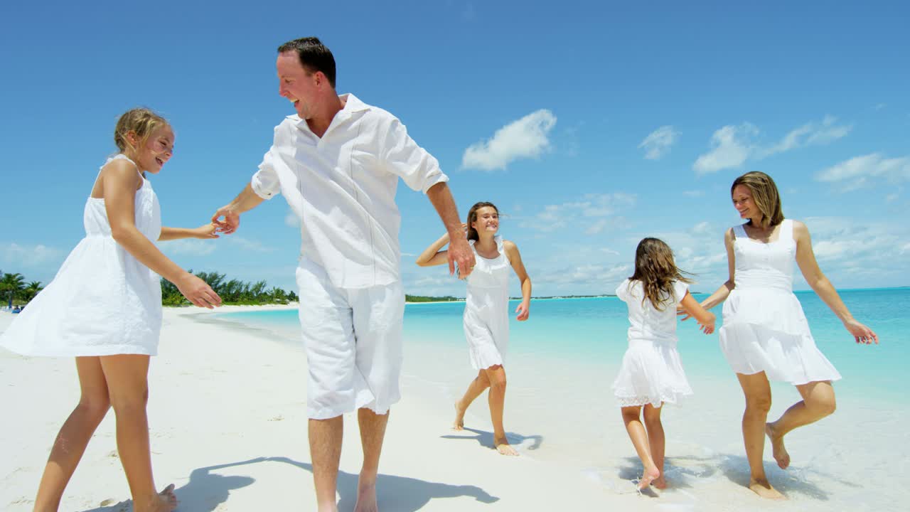 백인 부모 와 그 들 의 여자 자녀 들 이 해변 을 즐기고 있다