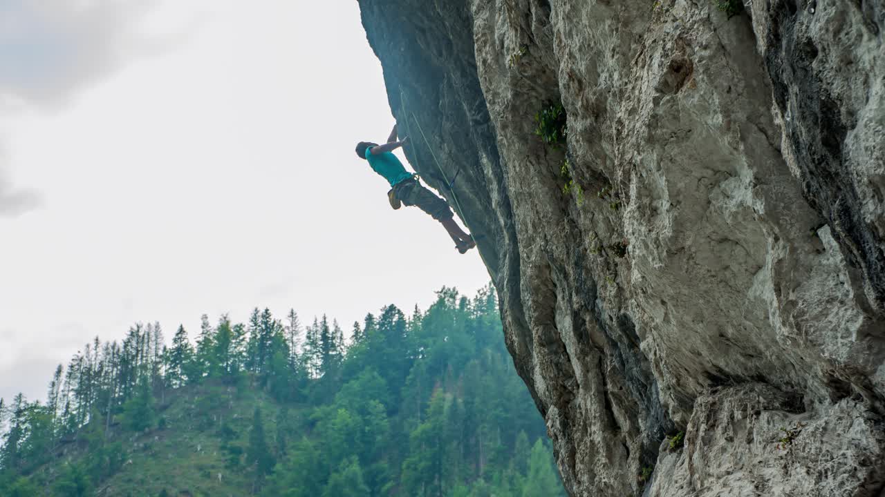 Adult Male Climbing Cliff Wall And Falls And Hangs In Air At Burjakove Peci. Slow Motion