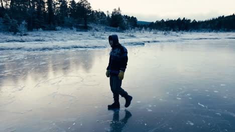 indre fosen, trondelag county, norway - a man strolling across the icy surface of omundvatnet - tracking shot