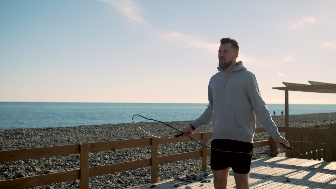 해변에서 로프를 뛰어넘는 남자