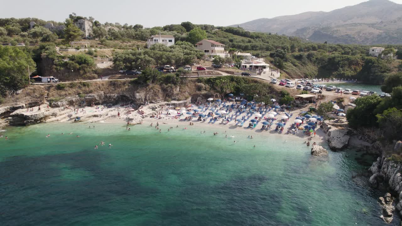 Bataria Beach in Kassiopi, Pebble small beach with crystal clear water, Corfu Island, Aerial Orbiting