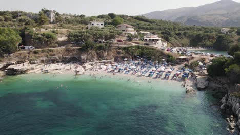 Playa-De-Bataria-En-Kassiopi,-Pequeña-Playa-De-Guijarros-Con-Aguas-Cristalinas,-Isla-De-Corfú,-órbita-Aérea