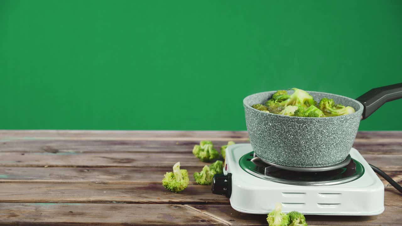 Fresh broccoli cooked in a saucepan. On green screen.
