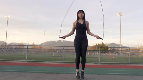 gimbal low angle shot of asian woman jumping rope outdoors