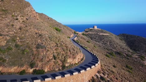 Aerial-view-of-mountain-with-a-trekking-path-and-roadway-for-travel-surrounded-by-calm-and-silent-sea-in-the-beautiful-city-of-Benidorm-in-Spain