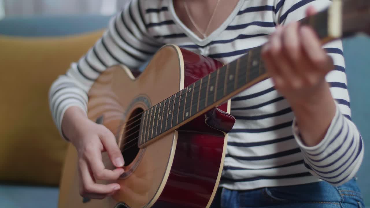 una chica tocando la guitarra acústica.