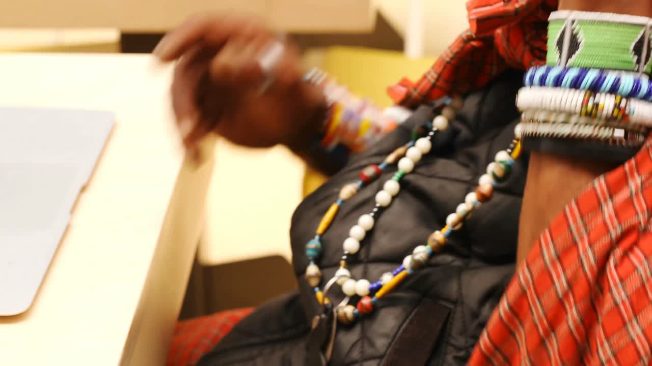 Tribal man talking on mobile phone while using laptop 4k