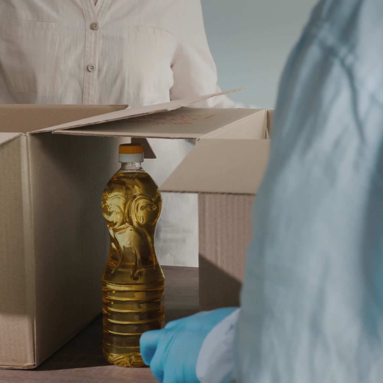 los voluntarios empacan alimentos en cajas de cartón con guantes y máscaras médicas 1