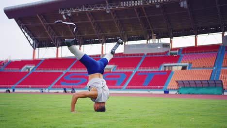 para athlete performing handstand in stadium