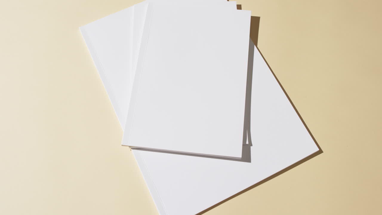 Video of books with blank white pages and copy space on yellow background