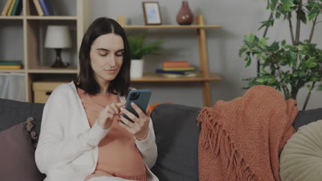 pregnant woman using smartphone at home