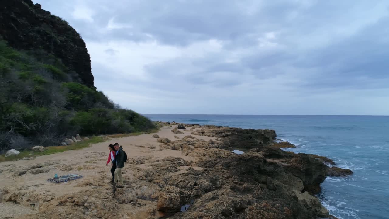 바다 해안에서 멀리 걸어가는 커플 4k