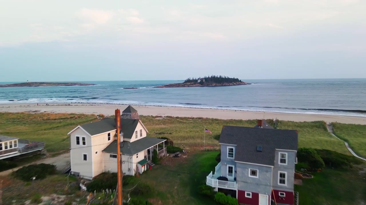 Luftfoto fra overflyvning af kystnære victorianske strandvillaer og klitter med amerikansk marehalm, der afslører Wood Island og den uberørte, afsidesliggende feriedestination Popham Beach i Phippsburg, Maine