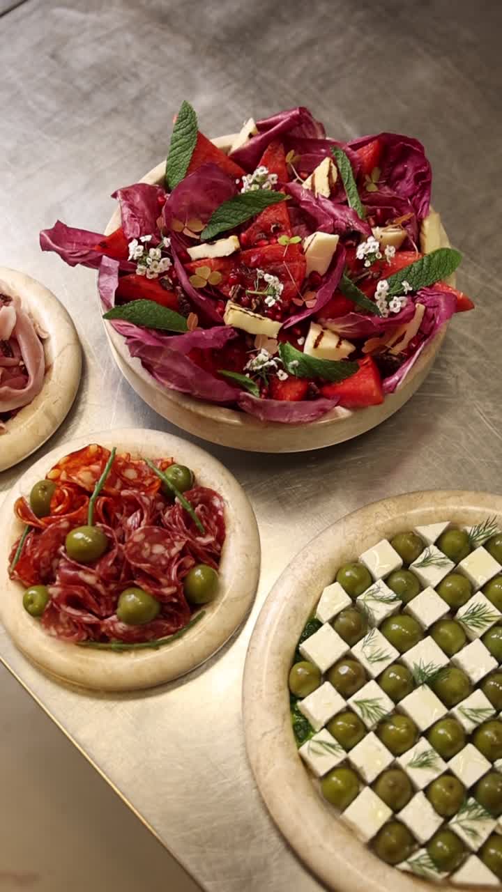 Assortimento di antipasti freschi tra cui insalata, salame e feta