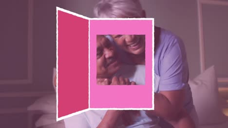 icona de tarjeta de felicitación de navidad contra una pareja de ancianos afroamericanos abrazándose en casa