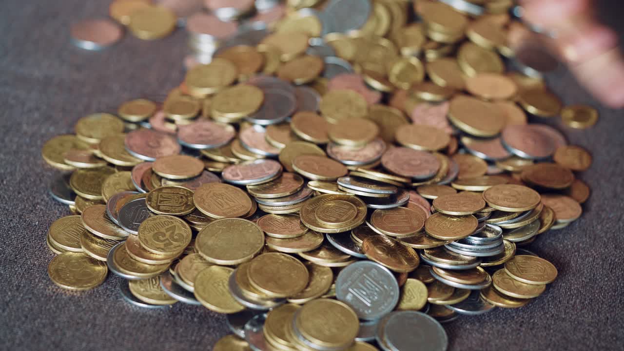 Child plays with coins. Large pile of money coins