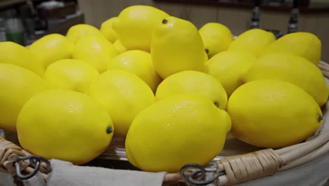 limones amarillos brillantes en un recipiente en exhibición, reluciente con condensación