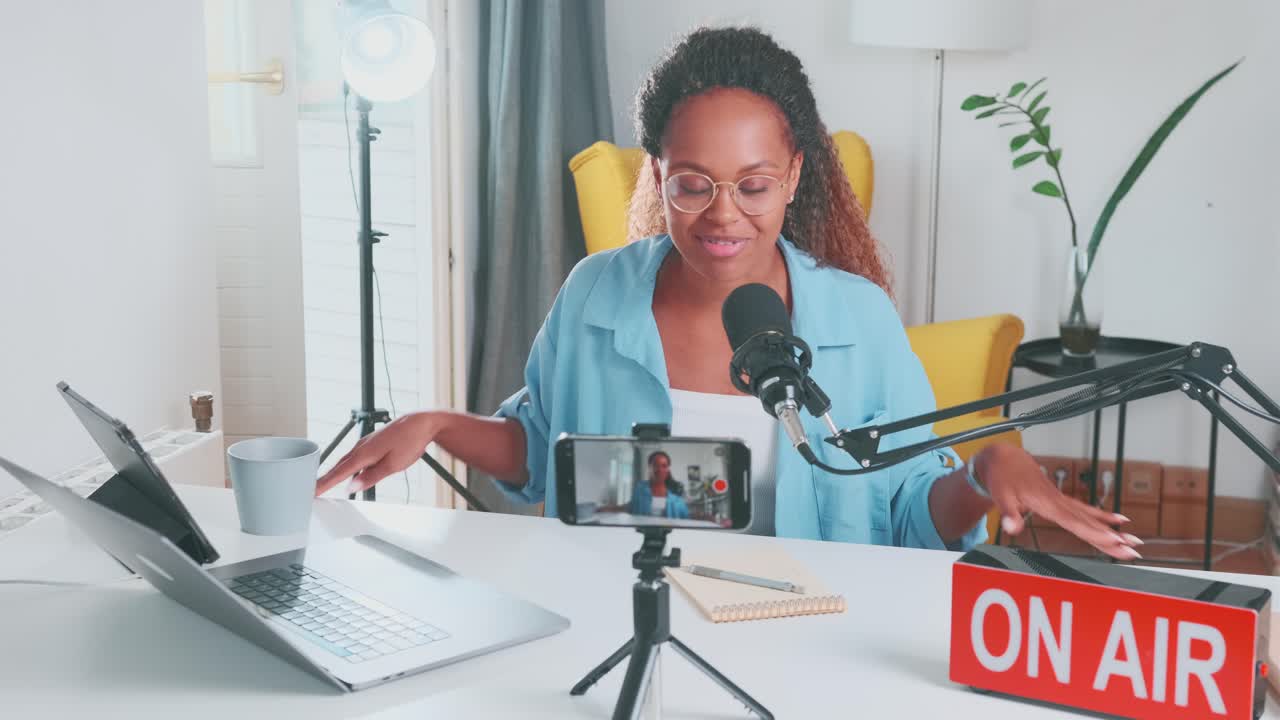 Young happy african american woman blogger records blog on mobile phone camera