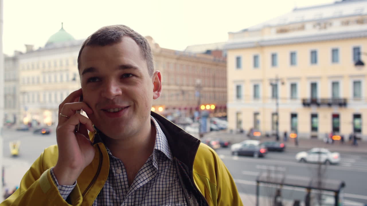 밖에서 전화로 얘기하는 흥분된 젊은 남자