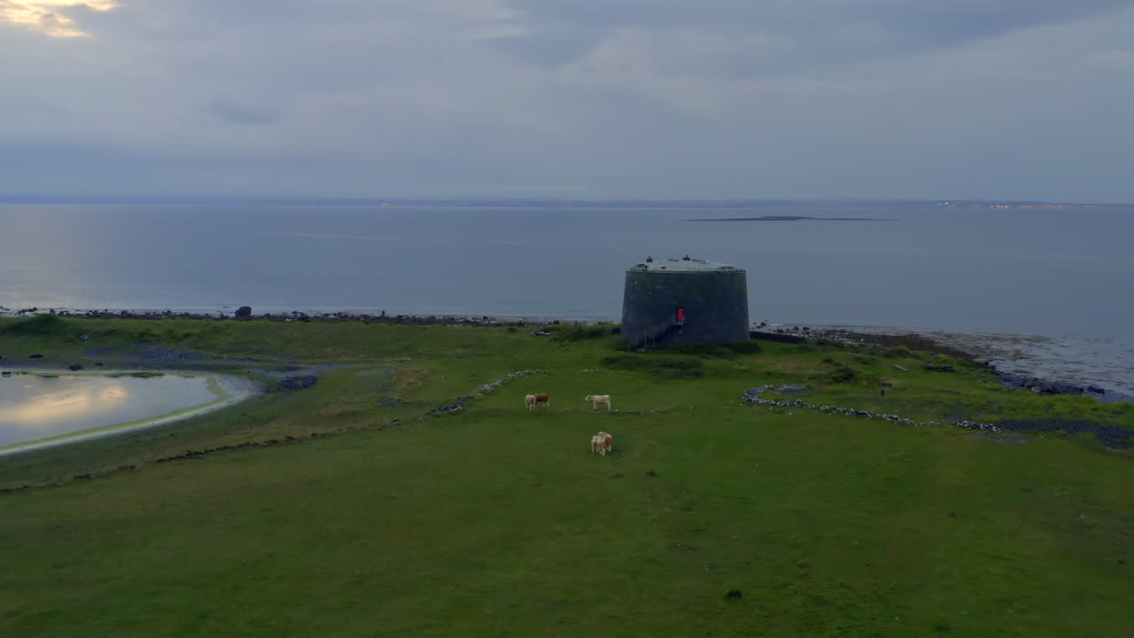Establishing aerial shot of Aughinish Martello Tower on a peaceful twilight. County Clare