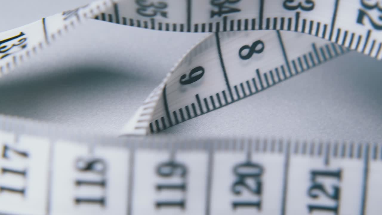 회색 배경에 센티미터와 함께 과거 운동 테이프 측정