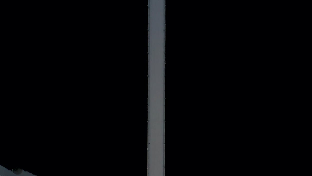 вид с высоты птичьего полета на подвесной мост над черной темной водой