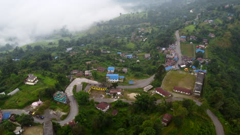 Vista-De-Pájaro-Del-Vibrante-Y-Colorido-Pueblo-En-La-Ciudad-Montañosa-De-Nepal-Mientras-Las-Nubes-Se-Asientan-En-El-Valle-De-Abajo