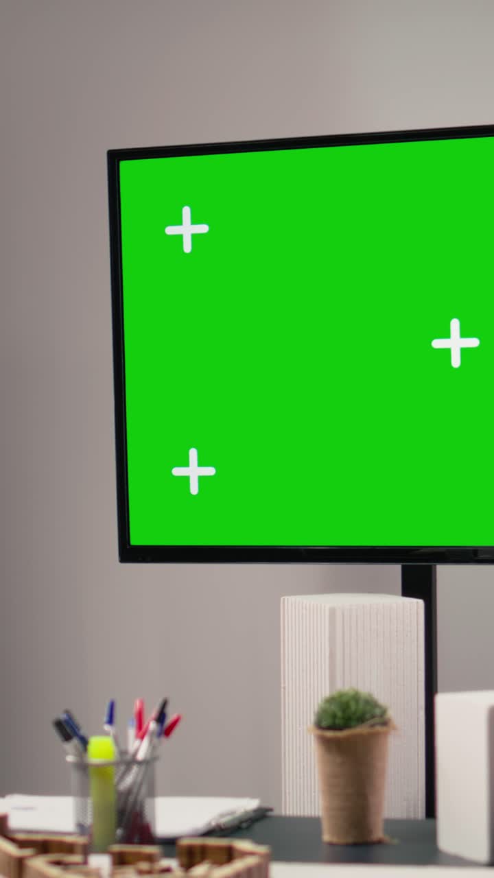 Video verticale. Ufficio immobiliare vuoto con un'enorme TV con schermo verde isolato in un hub di innovazione.