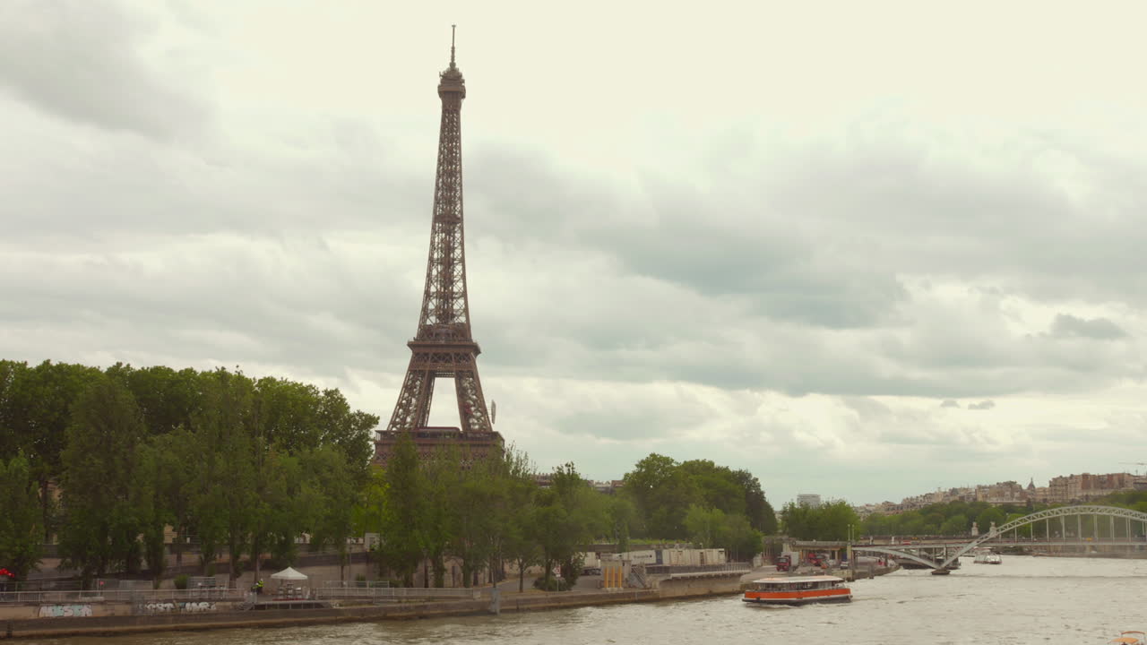 Eiffel Tower and Seine River with a boat on a cloudy day in Paris